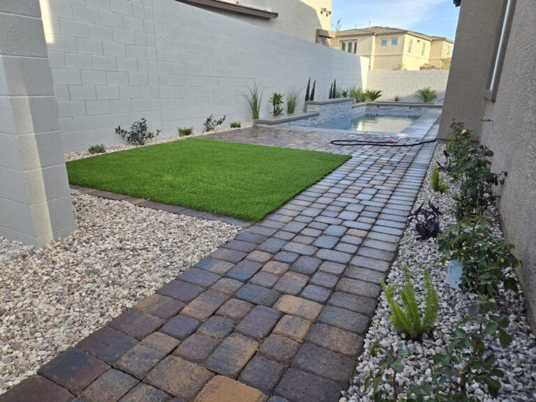Artificial turf and paver patio by the pool in Henderson, NV